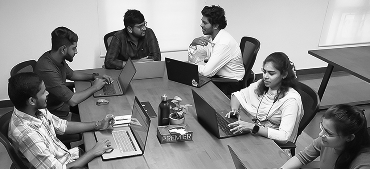 pS squad sitting around a table with laptops.